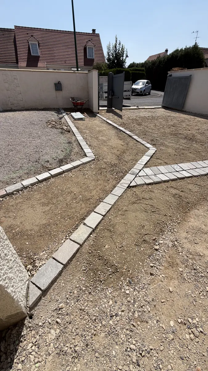 Lignes de pavés posées en lignes brisées sur un sol préparé