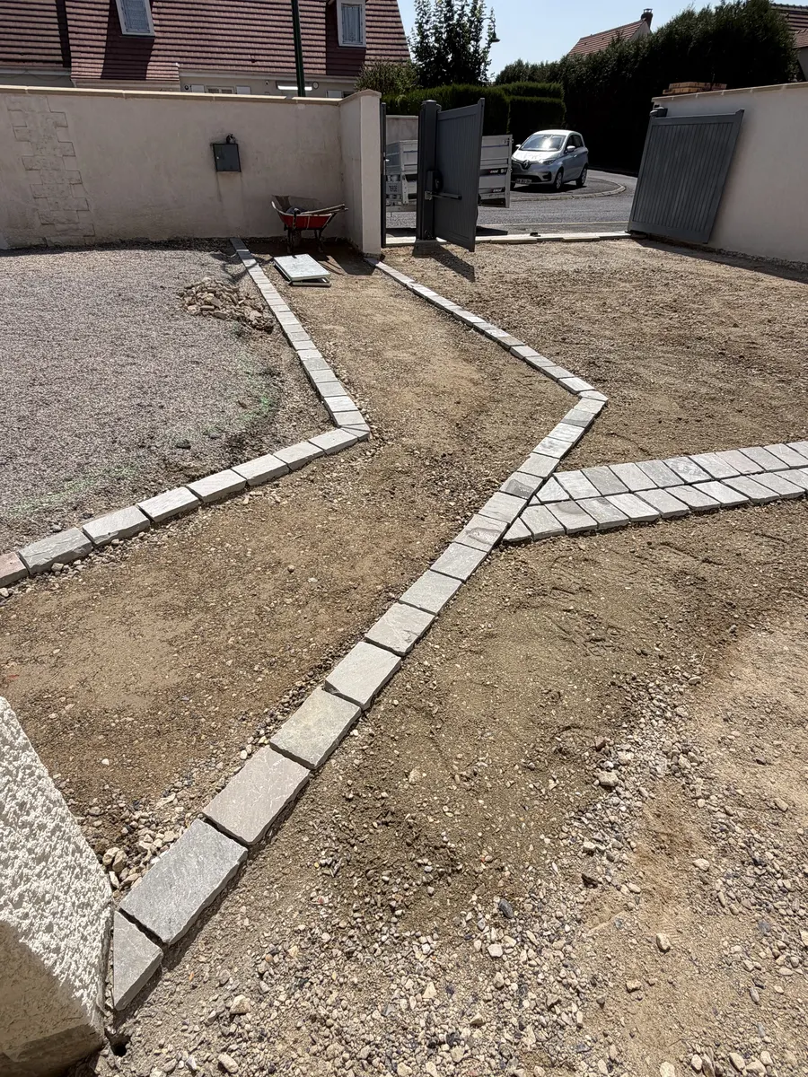 Lignes de pavés posées en lignes brisées sur un sol préparé