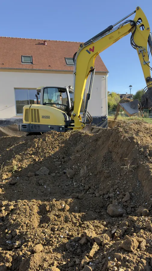 Pelle jaune au pied de la maison, terrain terrassé