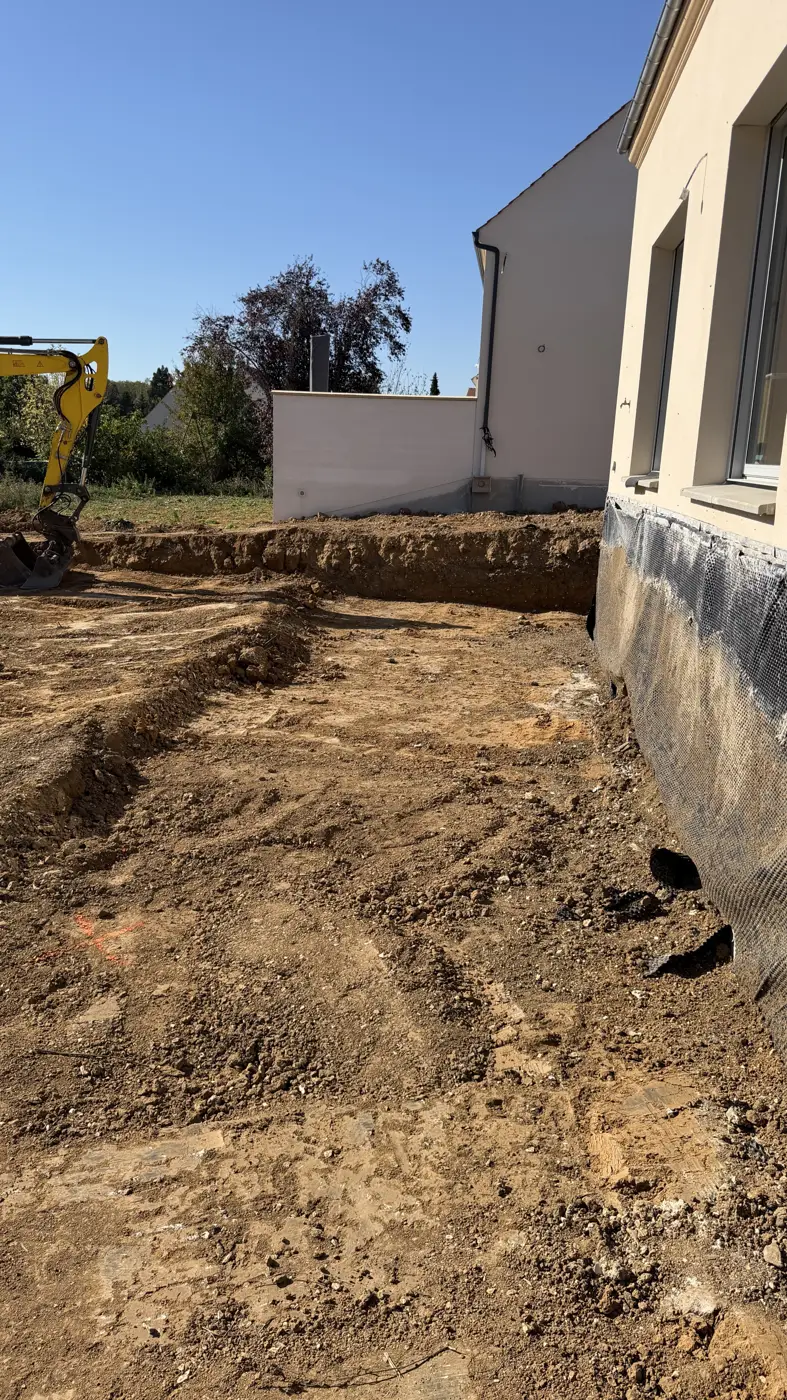 Terrain terrassé derrière une maison neuve à Bornel, pelle au fond