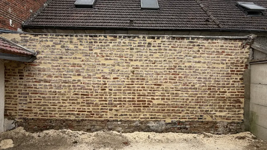 Mur de briques extérieur rejointoyé ton pierre, sous le toit