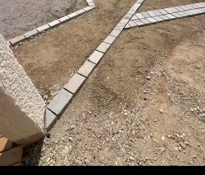 Lignes de pavés posées sur le sol préparé