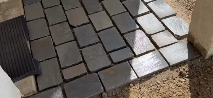 Petit pavage en pavés anthracite devant la porte
