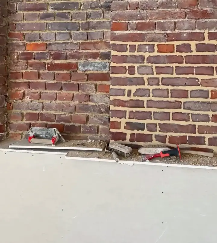 Joints refaits au mortier ton pierre sur le mur de briques