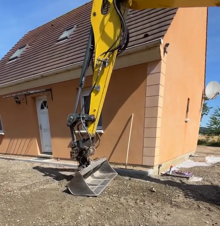 Compactage de la grave à la pelle devant la maison