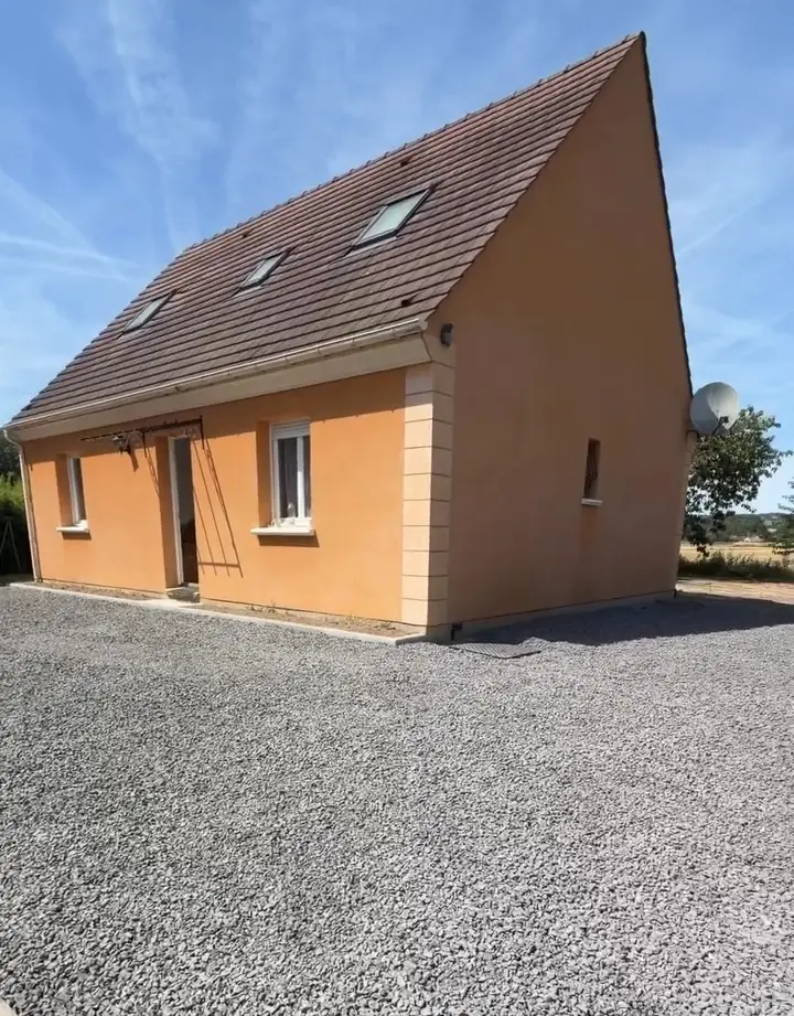 Stationnement en gravillons terminé devant la maison orange
