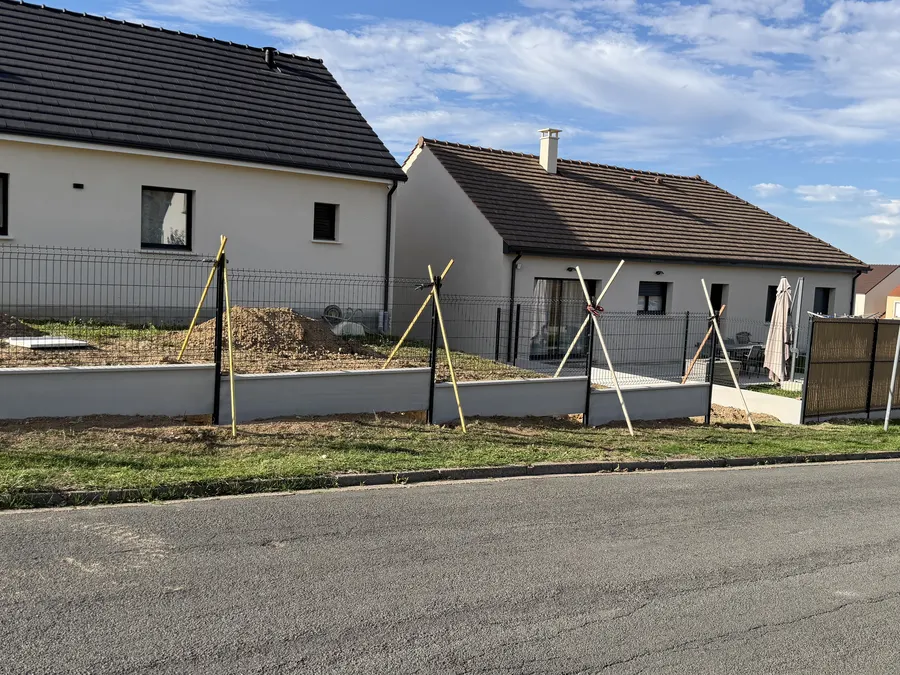 Clôture rigide sur soubassement devant deux pavillons