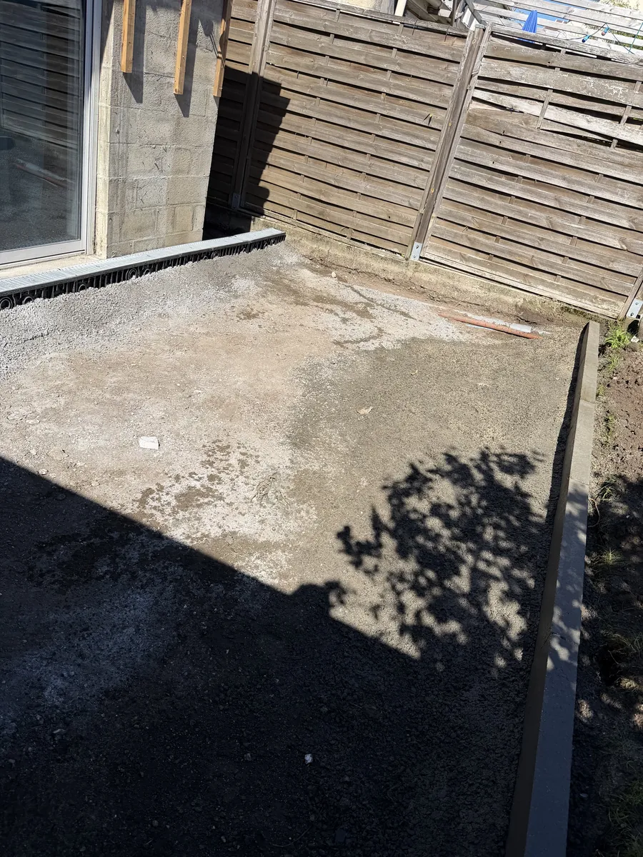 Sol de terre et de gravats au pied d'une maison, avant une terrasse