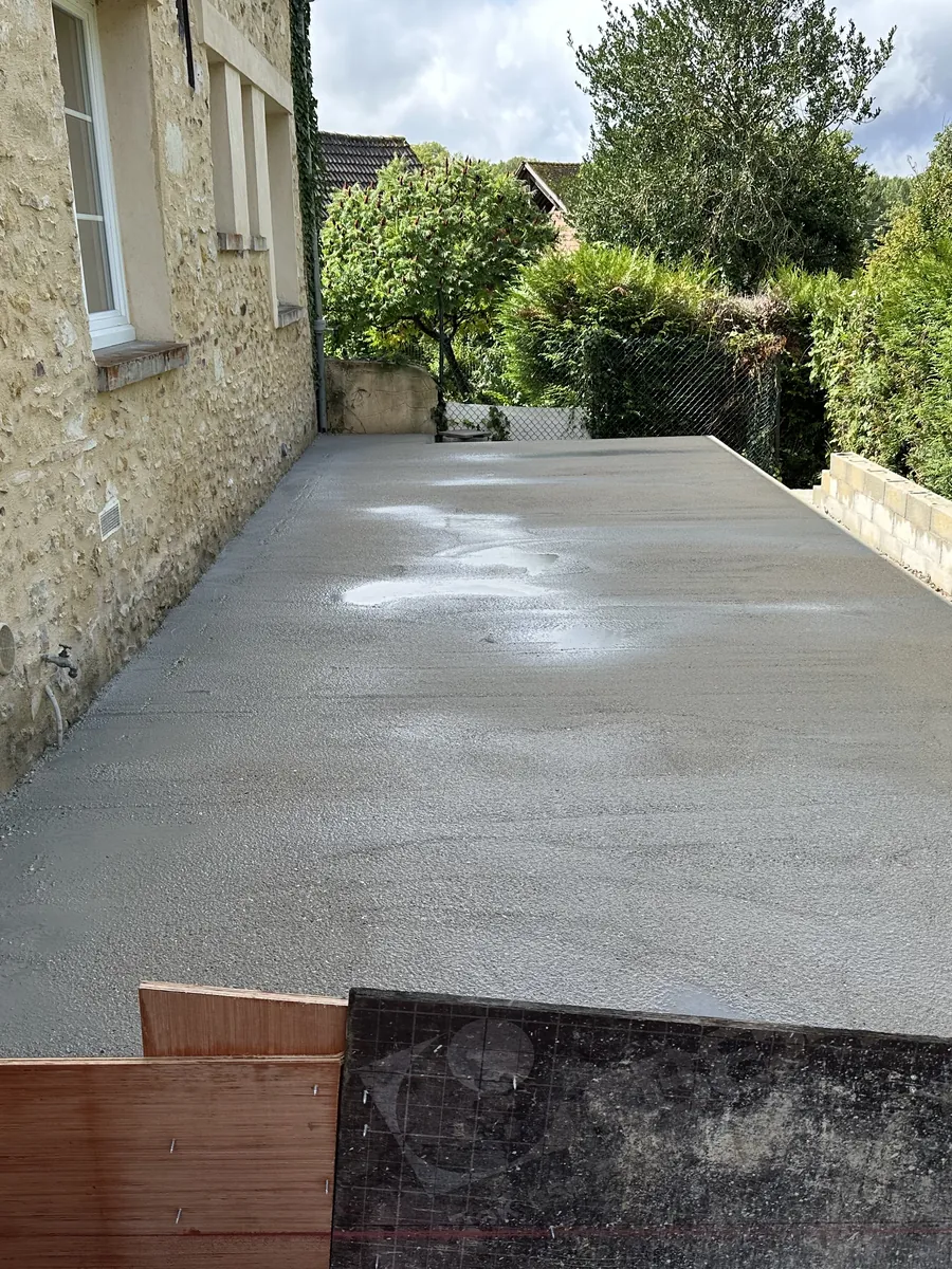 Béton frais coulé le long d'une maison en pierre