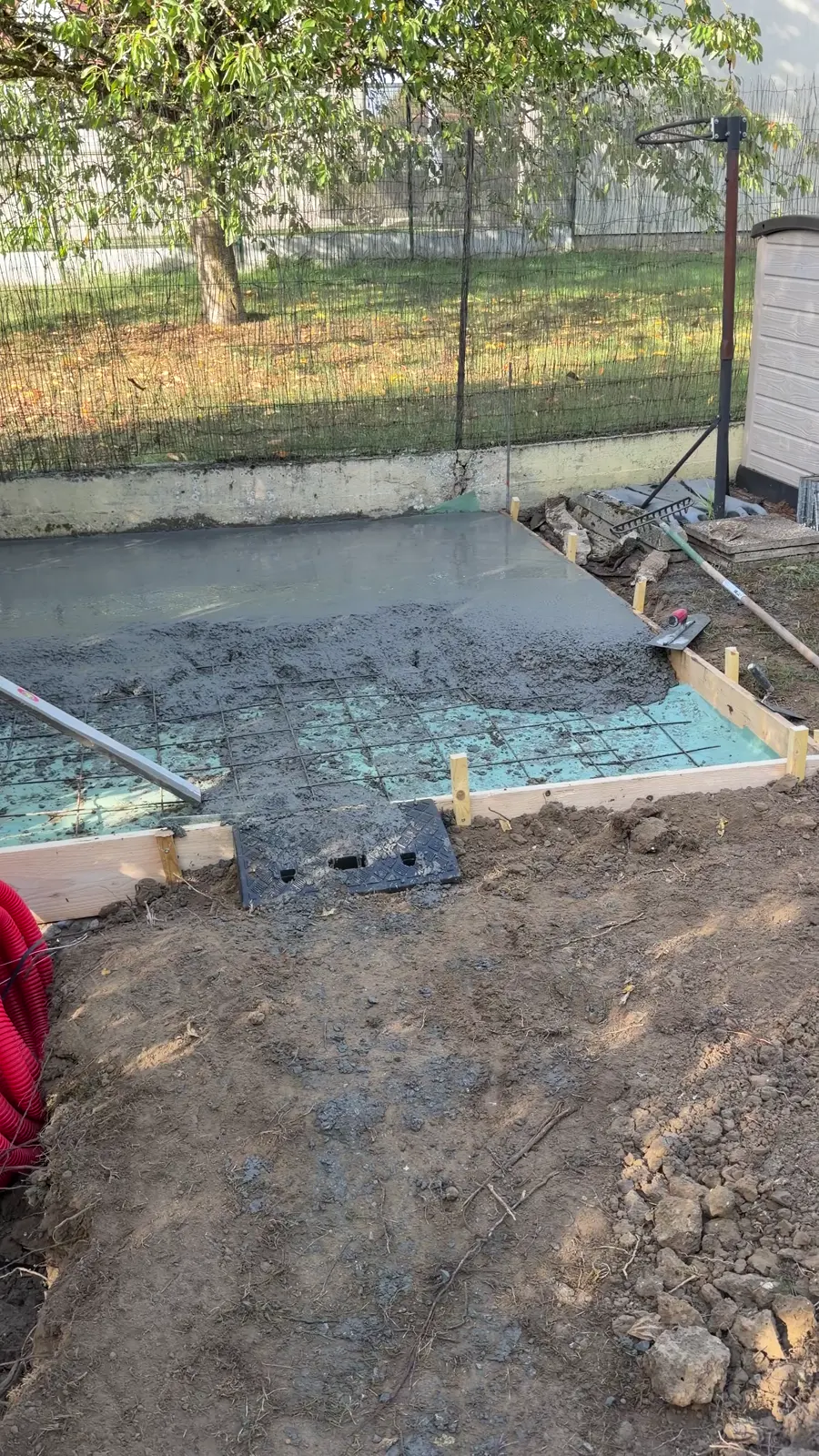 Béton coulé sur le treillis, dans le coffrage, au fond d'un jardin