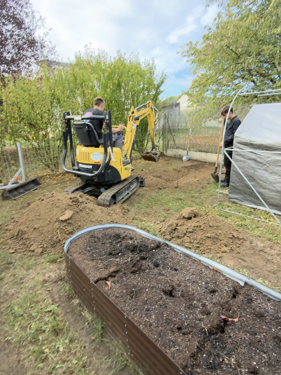 Mini-pelle qui décaisse le terrain d'un jardin avant une dalle