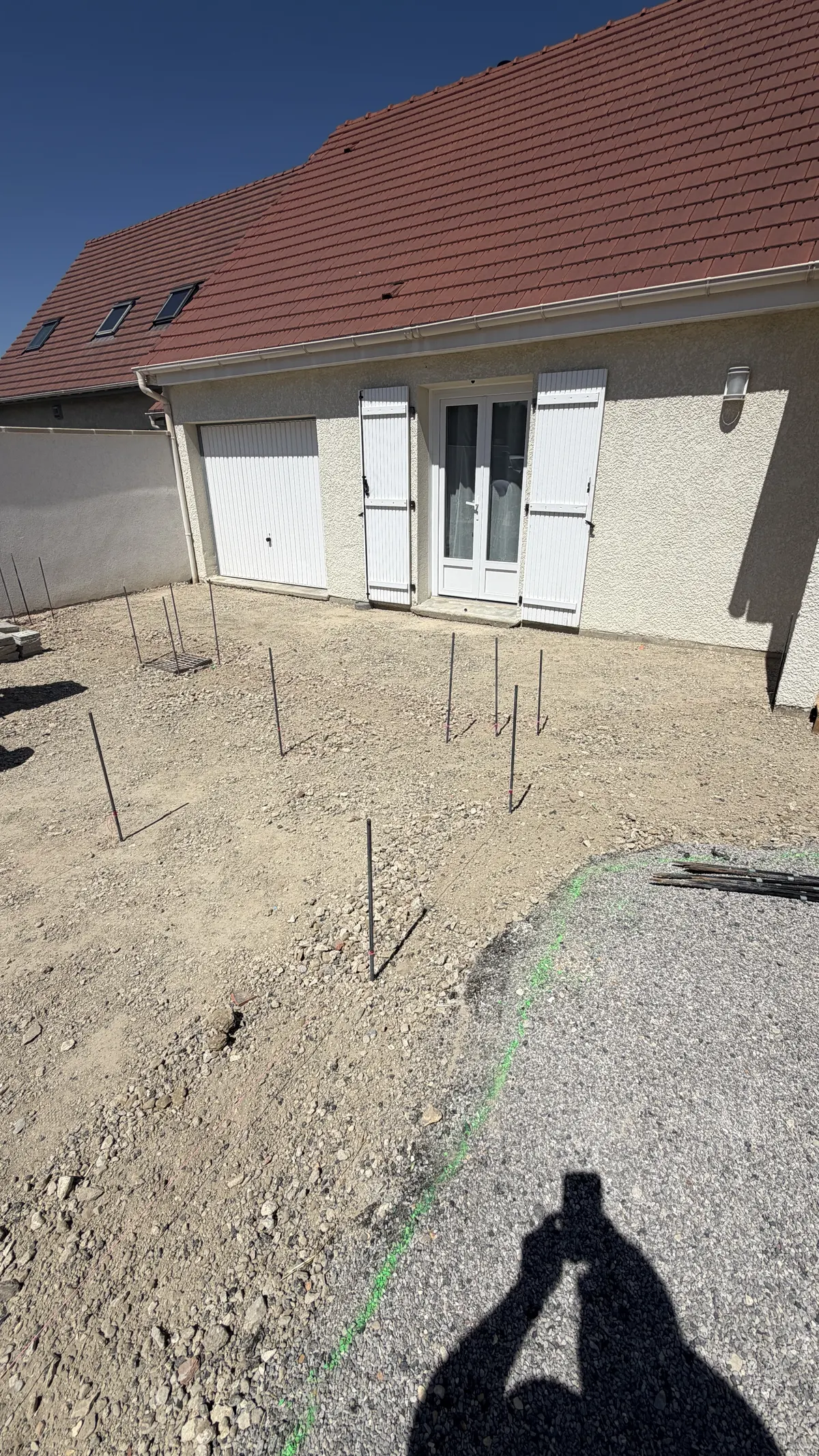 Fers d'implantation plantés sur le sol terrassé devant la maison